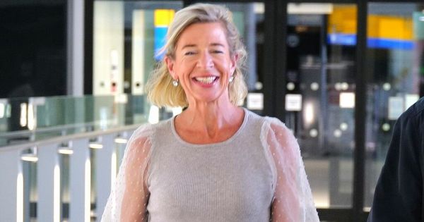 Katie Hopkins grins as she lands in the UK following Oz deportation