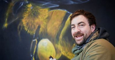 Street artist Qubek sprays Manchester bee mural at new city hotel