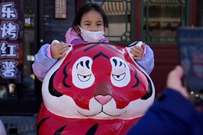 On Lunar New Year, Chinese pray outside shut temples