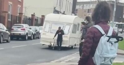 Man spotted wheeling caravan through streets of city leaving onlookers baffled