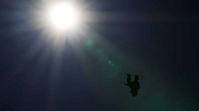 Silhouetted, Olympic Snowboarder Hangs in Mid-Air