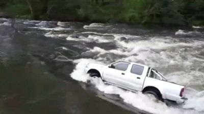 Couple plucked from ute stuck in raging floodwaters as dramatic flood rescue is captured on camera