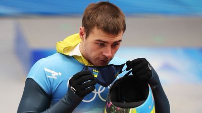 Ukrainian Olympian holds up "No War" sign after race