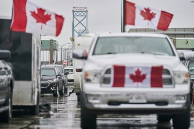 Canada truckers defy order to clear key bridge as protests swell