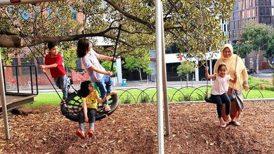 Melbourne's Lincoln Square separates two groups of Afghan refugees. Only one of them is allowed outside to enjoy it