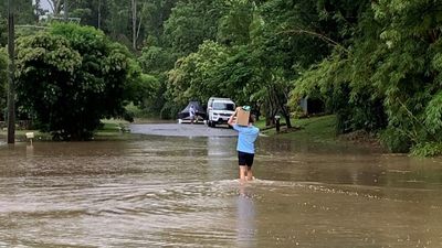 Woman dies in floodwater after Queensland records 'scary' amount of rain, BOM warns of more to come