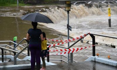 Woman dies in Queensland flooding as stormy weather pummels NSW and south-east Queensland