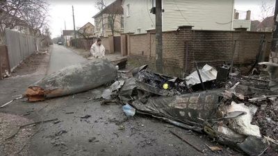 Kyiv residents clear away rubble and await Russian assault