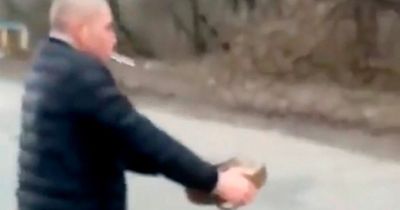 Heart-stopping moment Ukrainian man carries bomb away while puffing cigarette