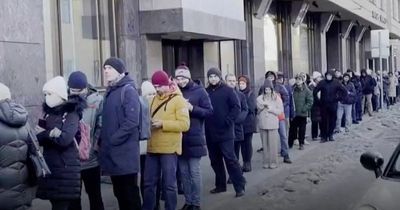 Desperate Russians queue for hours to withdraw money from banks as rouble plummets