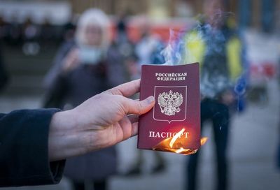 Campaigner burns Russian passport as hundreds gather for Ukraine vigil