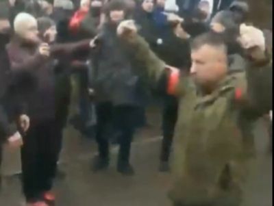 Russian soldier holding two grenades walks through Ukrainian crowd demanding they surrender