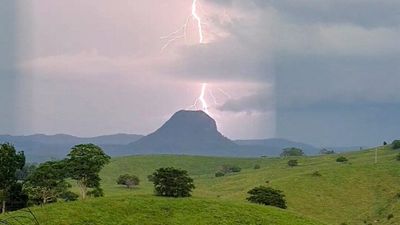 Man found dead after being swept off road during severe storms in Queensland