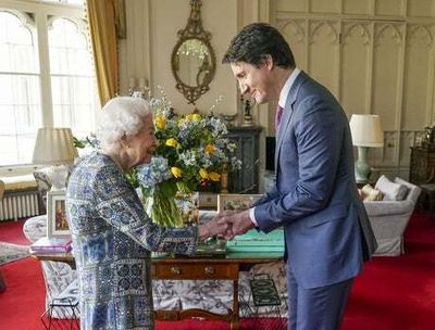 Queen holds in-person meeting with Justin Trudeau in front of blue and yellow flowers