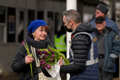 AP PHOTOS: Tulips, hugs for refugees on women's holiday