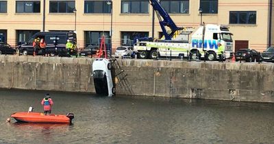 Audi lifted out of Queens Dock after driver plunged into the water