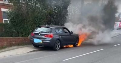 BMW bursts into flames as plumes of smoke billow into the air