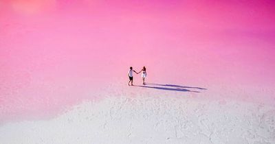 Couple capture ultimate romantic shots at magical fairytale-like pink lake