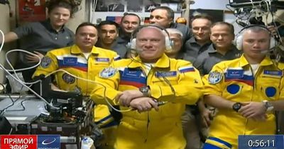 Three Russian cosmonauts wear colours of Ukrainian flag as they arrive on space station