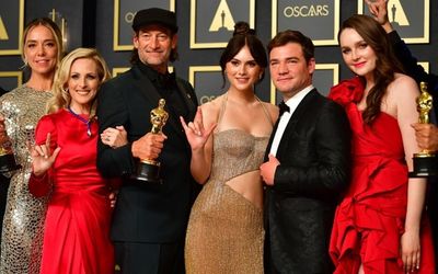 Oscars marred by controversy as feel-good film CODA wins top prize and makes history for Apple