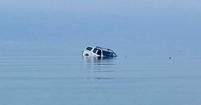 Moment unlucky motorist's vehicle becomes submerged in sea by incoming tide