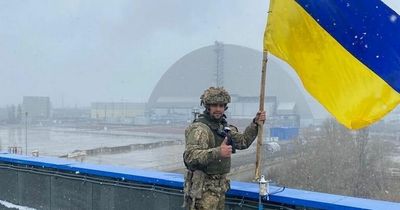 Ukraine soldier poses with flag at re-taken Chernobyl plant after Russian retreat