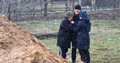 Grieving family huddle by mass grave in Ukraine as bodies continue to be found