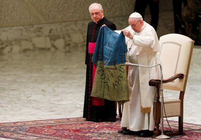 Pope, holding Ukrainian flag, condemns 'atrocities, such as the massacre of Bucha'