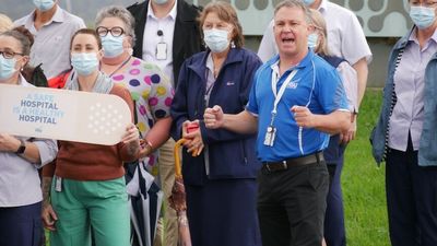 Thousands of health workers across NSW strike over 'draconian' wage cap