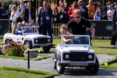 Drive time: Harry and Meghan ride in miniature Land Rovers