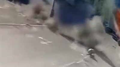 Moment Russian Airstrike Misses Ukrainian Woman Walking Down Street As It Destroys Trash Can