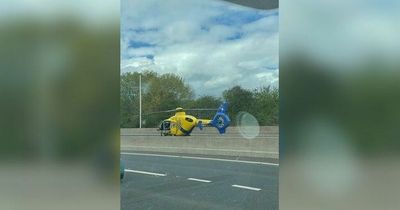 Biker taken to hospital after crash as air ambulance lands on road