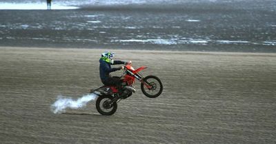 Crowds film scrambler biker in 'Mexican standoff' with police on beach