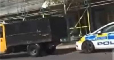 Dramatic moment tipper truck smashes into police car in daylight before driving off
