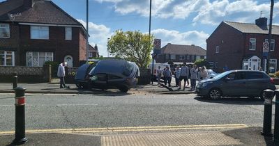 Car flips onto side after smashing into bollard