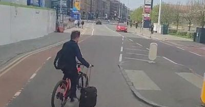 Dangerous moment an Edinburgh cyclist drags a suitcase behind him down busy road