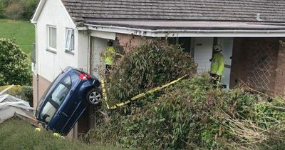 Pensioner rescued from car after crashing through wall and hanging over 10 foot drop