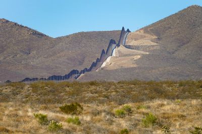 Autopsy: Woman migrant found on border wall choked to death