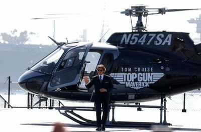 Tom Cruise lands helicopter onto aircraft carrier for Top Gun sequel red carpet