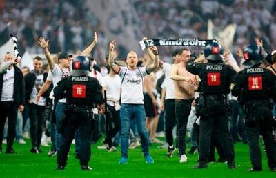 Riot police push Eintracht Frankfurt fans back after pitch invasion with two West Ham supporters arrested