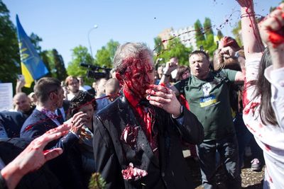 Russian ambassador attacked and drenched with red paint by Polish protesters