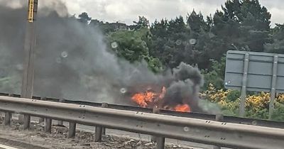 Emergency services rush to scene as car bursts into flames on busy Scots road