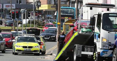 Heavily damaged car towed away after crash on busy road