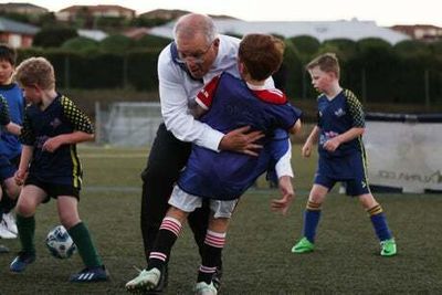 Australian prime minister Scott Morrison flattens boy during football match