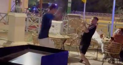 Football fans in violent street brawl throw chairs outside bar in Seville