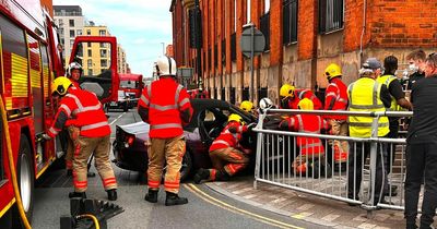 Firefighters descend as purple BMW smashes into side of old Salford hospital