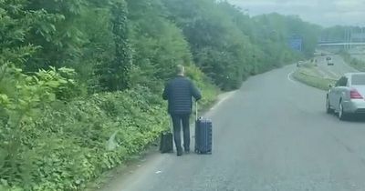 Video captures man WALKING down the A555 with suitcases near Manchester Airport