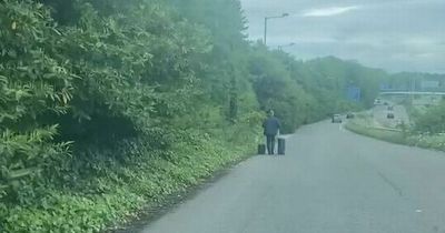 Video captures man walking down dual carriageway with suitcases near Manchester Airport