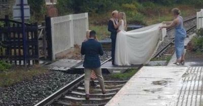 Bride and groom slammed for wedding photo pose on train tracks as guests watch