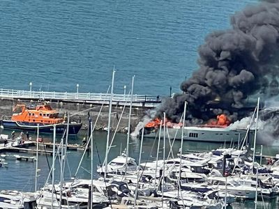 Work under way to prevent pollution after burning superyacht sinks in marina